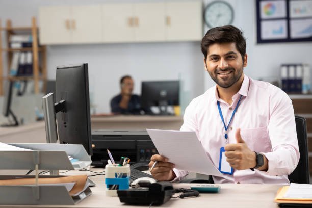 businessman with computer reading documents in office